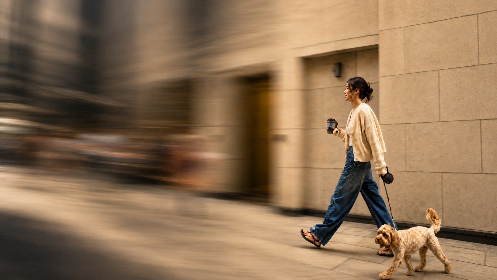 Woman walking with a Mouggy leopard-print cup and a fluffy dog on a leash